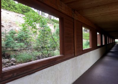 Hallway of condo comples with neat windows on its closed side to keep out hillside snow
